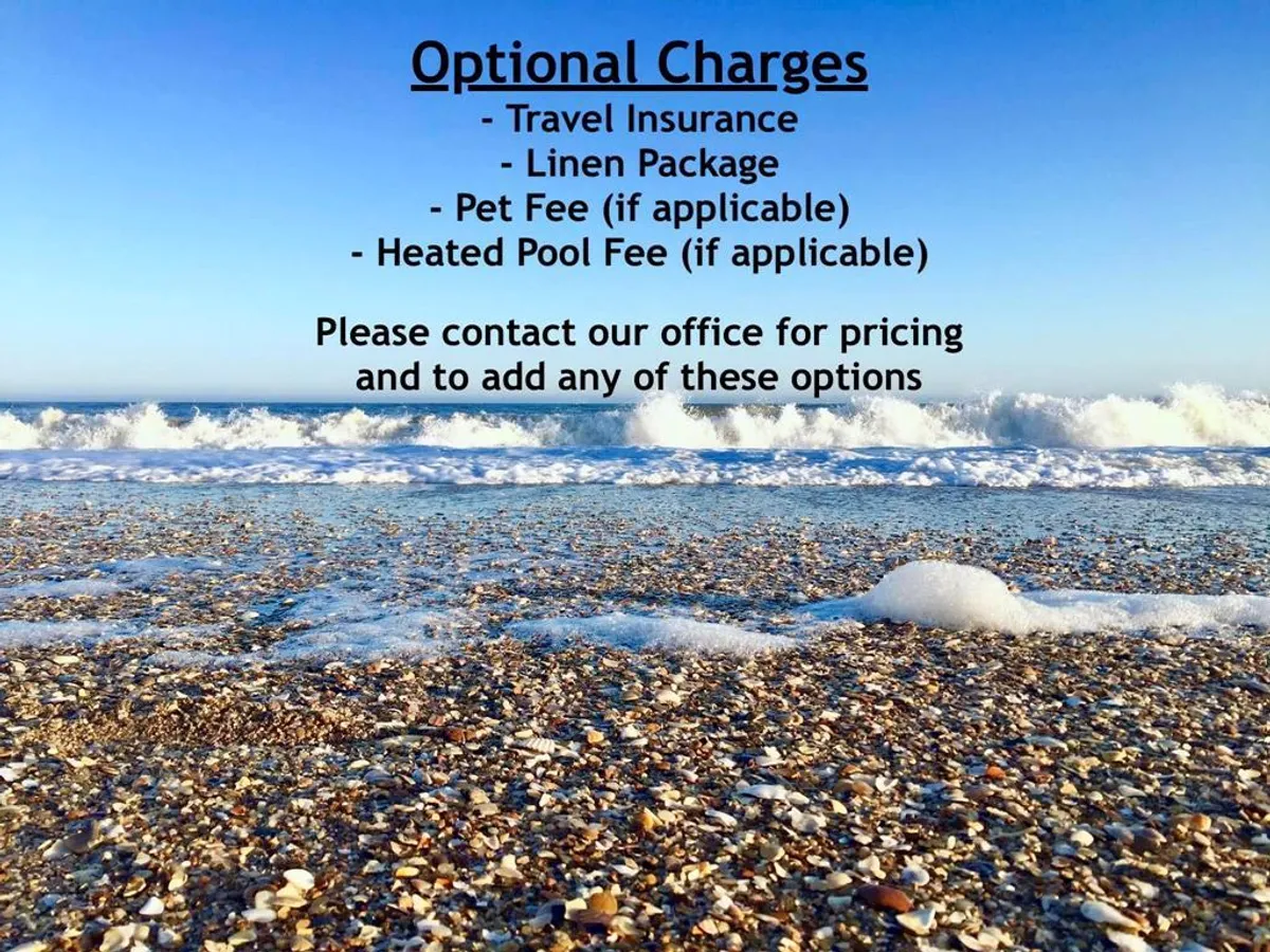 This image captures a tranquil stretch of sandy beach under a blue sky, with gentle waves rolling ashore and scattered seashells. The scene is inviting for beachgoers, highlighting easy access for swimming, sunbathing, and relaxing by the water.